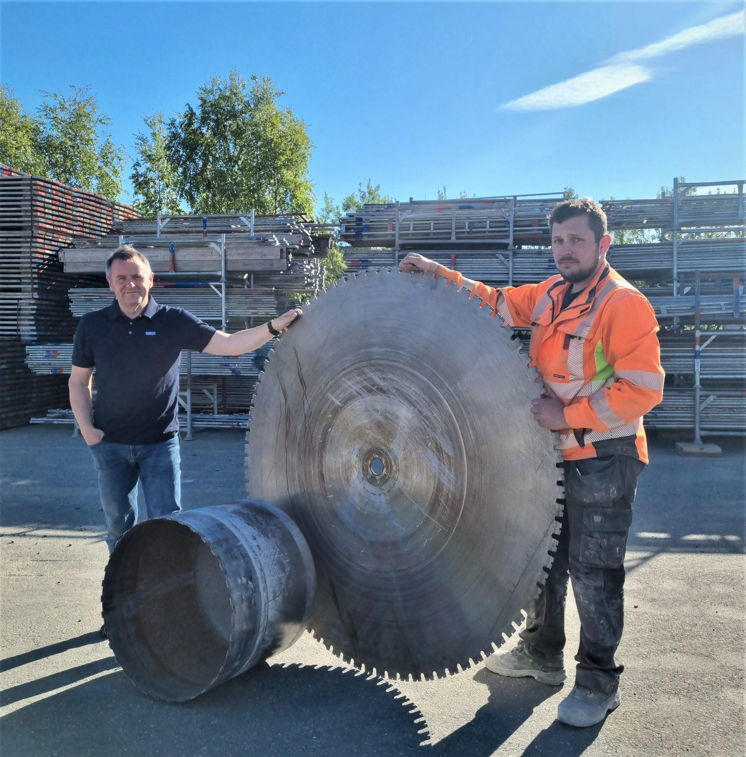 To menn ved et stort sagblad for betongsaging